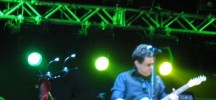 Calamaro on stage with guitar and squid amulet