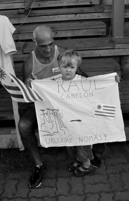 Man with kid bearing handwritten sign to cheer him in the Decathlon