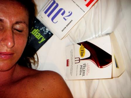 Woman in bed with books: E=mc square, The Devil wears prada